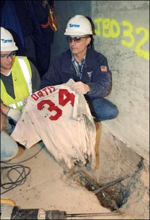 Frank Gramarossa, right, project executive for the new Yankee Stadium, removes a Red Sox jersey from the ground.