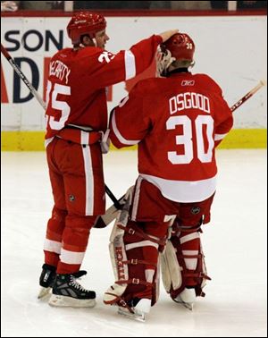 Red Wings winger Darren McCarty, left, congratulates goalie
Chris Osgood after Detroit s overtime victory Friday night.
