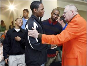 Bill Frack, right, talks with Bowling Green State University basketball players Darryl Clements and Brian Moton after being honored for his $2 million gift to the school.