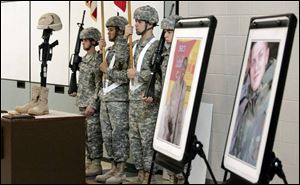 The 983rd Engineer Battalion color guard stands in the Army Reserve unit s headquarters by portraits of
Sergeant Frederick and Sgt. Gary  Andy  Eckert, Jr., yesterday.
