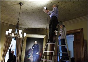 Albert Albano, executive director of the Cleveland-based Intermuseum Conservation Association, and Emily Helwig, a paper conservator, examine the drawing room ceiling.