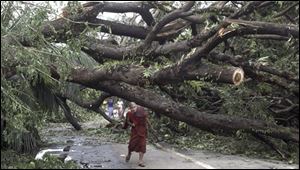 A Myanmar Buddhist Monk makes his way past a fallen tree following a devastating cyclone on Sunday, in Yangon. The death toll from the cyclone has risen to almost 4,000, a Myanmar state radio station has said. 