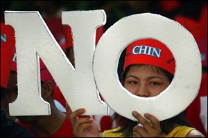 A Myanmar protester holds placard reading 