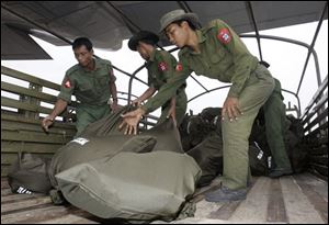 Myanmar soldiers unload bags of supplies aid, donated by Thai King Bhumibol Adulyadej, from a Thai military plane onto a truck at Yangon airport in Myanmar Sunday, May 11, 2008. More food reached Myanmar's hungry cyclone victims as roads were cleared of fallen trees, but a British aid group warned that up to 1.5 million face death if they do not get clean water and sanitation soon.