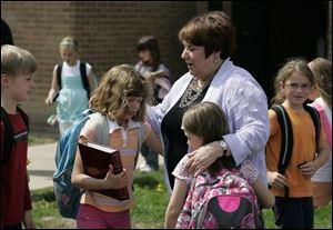 Toth Elementary Principal Beth Christoff says good-bye to students, from left, Nick Wietrzykowski, Lauren Christoff (no relation), and Breehan Connor at the end of the school day.