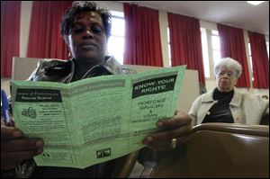 Mary Chavis, left, looks over information as she and Rachel Gibbs of New York City attend a church workshop on surviving the mortgage crisis.
