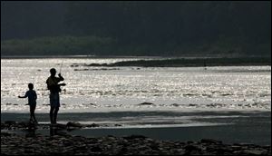 A father and son try their luck at fishing in the Maumee River during an outing at Side Cut Metropark in Maumee.