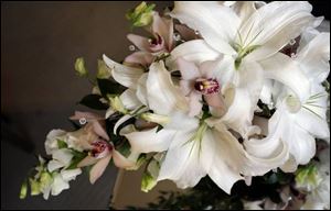 A streamlined cascade pf white lilies, cymbidium orchids, white sweet pea, and crystal gems.