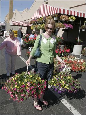Amy Riese of Toledo has her hands full after checking out the vendors at the event near the Erie Street Market.