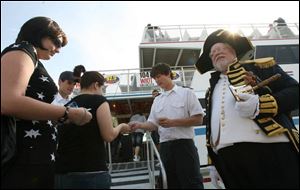 Ali Michalak, far left, and Kim Anderson, center, hand tickets to Billy Keller, back right, and Tim Herrle, back left, as Michael Lieber stands by in town crier costume.