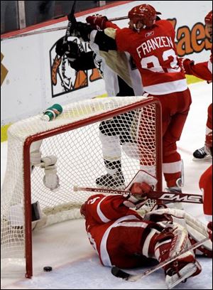 Red Wings goalie Chris Osgood can t stop a shot by Maxime Talbot, top, with 35 seconds left in regulation. It tied the game at 3.
