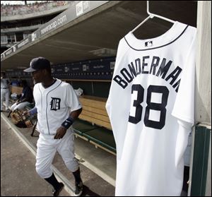 Jeremy Bonderman's jersey hangs in the dugout as shortstop Edgar Renteria takes the field. Renteria later hit a grand slam.