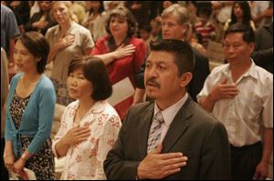 Xiangqing Sun, formerly of China and now of Genoa, Sang Ye Warner, formerly of South Korea and now of Clyde, and Jesus Alberto Guel, formerly of Mexico and now of Toledo, become U.S. citizens in Toledo. 