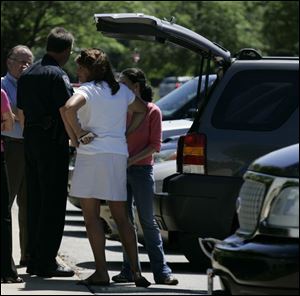 Former party Executive Director Joanne Wack, in white,
stands next to her vehicle after Maumee police were called in response to a report of items being removed from the office.