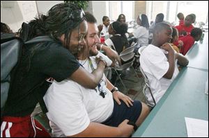 Program employee Jaye Hayes hugs group leader Matt Rubin, a UT sophomore, before he takes his group outdoors.