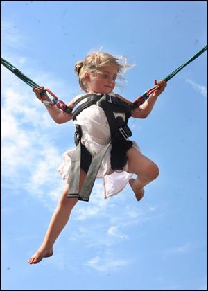 Slug:  NBRW blessed19p    Date: 6/15/2008             The Blade/Amy E. Voigt       Location:  Toledo, Ohio  CAPTION: Maggie McWhinnie (cq), 4, from Toledo, jumps on a bungee during the Blessed Sacrament Parish Festival which featured games, food, bingo, and music on june 15, 2008.