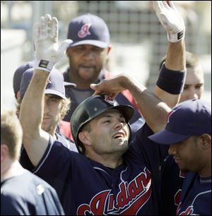 Jamey Carroll gets congratulated in the dugout after scoring the go-ahead run in the 11th inning for the Indians. After getting swept in Denver, Cleveland can sweep the Dodgers today.