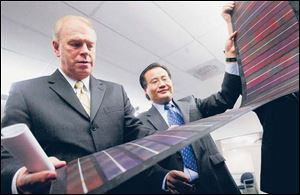 Gov. Ted Strickland examines a solar panel with Xunming Deng of Xunlight Corp. in November,
2007. Citing Xunlight and First Solar, Frank Calzonetti, a University of Toledo research and development
offi cial, suggests recognition of the area as a technology cluster is on the horizon.
