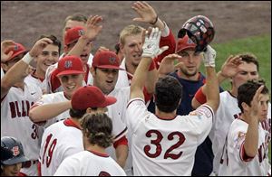 Teammates greet Fresno State s Tommy Mendonca (32) after
he slugged a three-run home run against Georgia last night.

