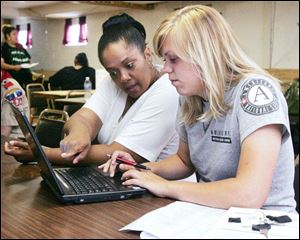 Food stamp outreach worker Anita Sanders and Carrie Riddle, an AmeriCorps VISTA member, await clients needing food stamps at Dominion Christian Center.
