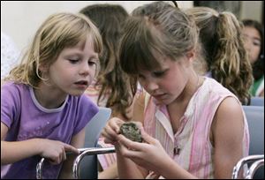 Hailey Park, 5, left, and sister Lindsay Park, 9, of Hudson, Ohio, examine a rock at the event at Port Clinton, Ohio. The children, guided by magnate Andrew Carnegie - or George Dauler- learned about steel. 