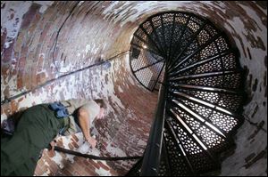 Dianne Rozak, naturalist at Marblehead Lighthouse State Park, climbs the 77 spiral steps to reach the observation deck.
