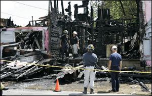 Investigators from the state Fire Marshal's Office search for clues in Weston, Ohio, for the cause of the fatal apartment fire.