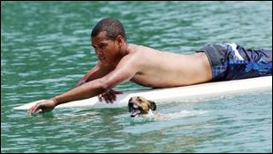 Derrick Garcia, 16, of Perrysburg retrieves his dog, Dudley, from the lake along Three Meadows Drive in Perrysburg. Dudley swam too far out in the lake while chasing ducks.