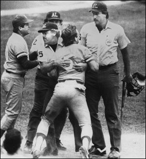 Umpire Joe Brinkman keeps George Brett from going after umpire Tim McClelland, who denied Brett s home run.
