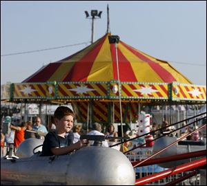 Slug: NBRE fair24p B                                           The Blade/Jeremy Wadsworth  Date: 07/15/08  Caption: Cameron Dodd, 5, of Toledo, Ohio, enjoys a ride Tuesday, 07/15/08, at the Ottawa County Fair in Oak Harbor, Ohio.