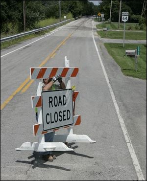Randy Allen stands behind his work as he removes barriers from State Rt. 64 on the north end of Haskins, Ohio.