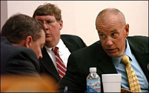 Lima police Sgt. Joe Chavalia, right, talks to his lawyers in a break in his trial in Allen County Common Pleas Court yesterday in the fatal shooting of Tarika Wilson in a drug raid.