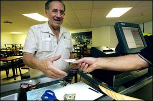 Leo McClosky of Toledo gets the first Keno printout at 11:04 a.m. yesterday at Raceway Park in Toledo. Across Ohio, games are played every four minutes between 11:04 a.m. and 1:44 a.m. 