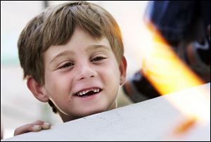 CTY artszoo11p  08/10/ 2008 The Blade/Dave Zapotosky Caption: Brandon Pokross, 7, of Sylvania, watches Gideon Rockwood, a flame working instructor at the Toledo Museum of Art, as he makes glass bananas during the Arts Gone Wild Event at the Toledo Zoo, Sunday, August 10, 2008. He was going to make a glass monkey to go along with the glass bananas he was making.  Summary: Arts Gone Wild at the Toledo Zoo.