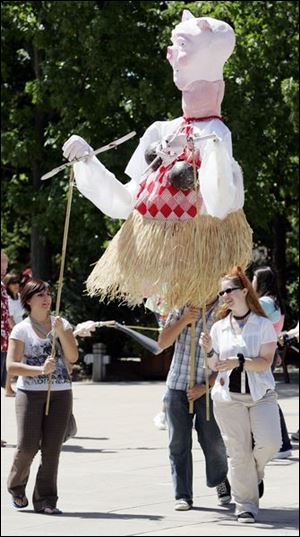 CTY artszoo11p  08/10/ 2008 The Blade/Dave Zapotosky Caption: Toledo School for the Arts students from left, Lindsey Sopko, 17, Jacob Parr, 17, and Hannah Blanc, 16, entertain visitors with a giant puppet they made at school, during the Arts Gone Wild Event at the Toledo Zoo, Sunday, August 10, 2008. Summary: Arts Gone Wild at the Toledo Zoo.