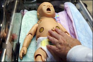 Nurse Cathy Wiegand feels the heartbeat of 'baby' Hal during a simulator class at St. Vincent Mercy Medical Center.