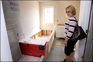 Carol Bintz checks out what will be her master bath. The geothermal system will also heat the energy-effi cient home s water.
