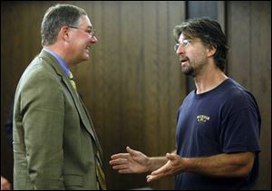 Bill Foster, left, of the Stranahan
Foundation, speaks to John Welch, who wants the building
at One Stranahan Square to be spared from demolition, after a forum for public comment over the United Way s decision to raze the
structure.
