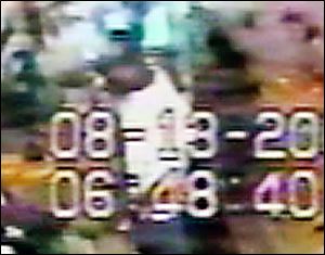A man twice looked over the counter where the clerk was shot, videotape shows.