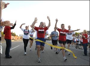 Michigan Gov. Jennifer Granholm and her husband, Dan Mulhern, finish the 51st annual Labor Day walk across the Mackinac Bridge with 275 other runners and 40,000 walkers.
