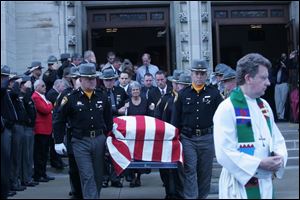 Widow Judy Gangwer follows her husband s casket out of Grace Lutheran Church in Fremont, en route to Oakwood Cemetery, where Sandusky County Sheriff David Gangwer was buried.