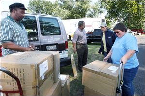Libbey Glass employees Willie Rivers, left, Karl Pendleton, center left, and Diana Skiles, right, deliver boxes filled with glassware to TV show employee Lynda Kalucki, in hat, in preparation for the home makeover. (BLADE PHOTOS/AMY E. VOIGT)
<BR>
<img src=http://www.toledoblade.com/graphics/icons/video.gif> <b><font color=red>VIDEO</b></font color=red>: <a href=