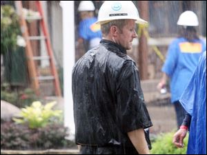 Mr. Schlachter works through rain at the Extreme Makeover site.
