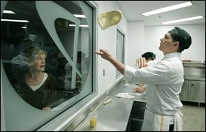 NBRW penta02p   09/28/2008 The Blade/Dave Zapotosky Caption: Linda Irving of Perrysburg watches Jared Koester, 17, of Millbury, Ohio, toss bread dough in the Culinary Connection at the Penta Career Center in Perrysburg, Ohio, during the school's open house Sunday, September 28, 2008.  Lake High School is Koester's home school. Summary: Open house at the Penta Career Center.