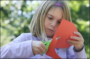 Slug: NBRE swamp09p                             Date: 10/05/2008             The Blade/Amy E. Voigt                     Location: Oregon, Ohio  CAPTION:  Lexi Rankin, from Milbury, cuts out a pumpkin to make a fall recipe card during the Black Swamp Festival at Pearson Park, Packer-Hammersmith Center on October 5, 2008 in Oregon. The free event included crafts, artisan demonstrations and entertainment.