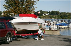 Don Pelchat of Holland unties his boat and prepares to tow it from the Rossford Marina with some assistance from Joe Jarvis of Perrysburg. 