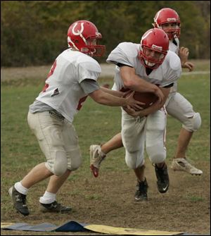 Bedford senior quarterback Nate Davis hands off to senior Doug Harmon. Both are tri-captains. Davis has rushed for more than 500 yards and passed for 458. Harmon has rushed for 878.
