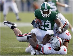 Michigan State running back Javon Ringer, who averages 147 yards and 33 carries per game, was stopped by Buckeyes
Malcolm Jenkins (2) and Nader Abdallah (93) on this play.
