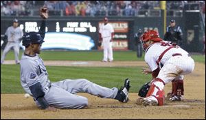 Tampa Bay's B.J. Upton scores the tying run on an RBI single by Carlos Pena before Carlos Ruiz can snag the throw in the sixth inning. Minutes later, the Phillies' grounds crew rolled out the tarp. The game was suspended less than an hour later.