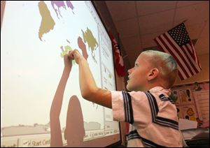 Third grader Philip Zaborski uses the Smart board at Ottawa River Elementary School.